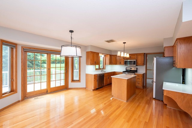 6262 Fernbrook Ln N, Maple Grove, MN 55311 - kitchen with stainless steel appliances, brown cabinets, a center island, light countertops, and light wood finished floors