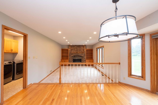6262 Fernbrook Ln N, Maple Grove, MN 55311 - unfurnished living room with washing machine and dryer, light wood finished floors, recessed lighting, and a fireplace