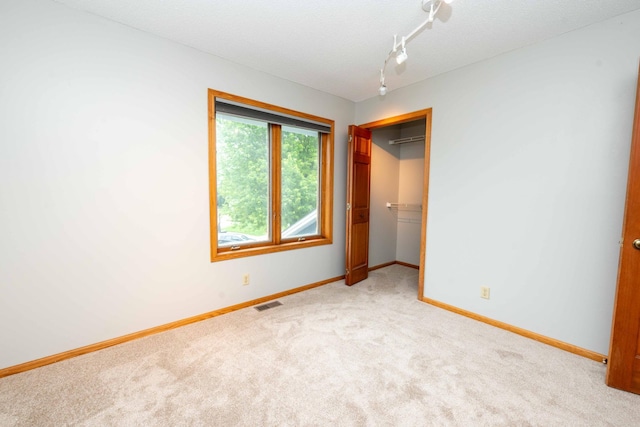 6262 Fernbrook Ln N, Maple Grove, MN 55311 - unfurnished bedroom with light colored carpet, a closet, rail lighting, and a textured ceiling