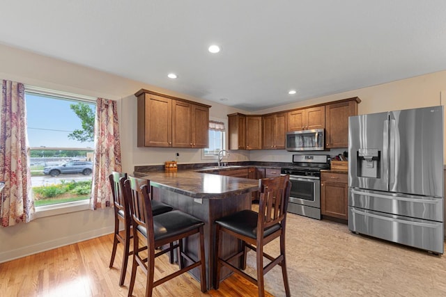 511 9th Ave SW, Faribault, MN 55021 - kitchen with stainless steel appliances, healthy amount of natural light, a kitchen breakfast bar, a peninsula, and recessed lighting