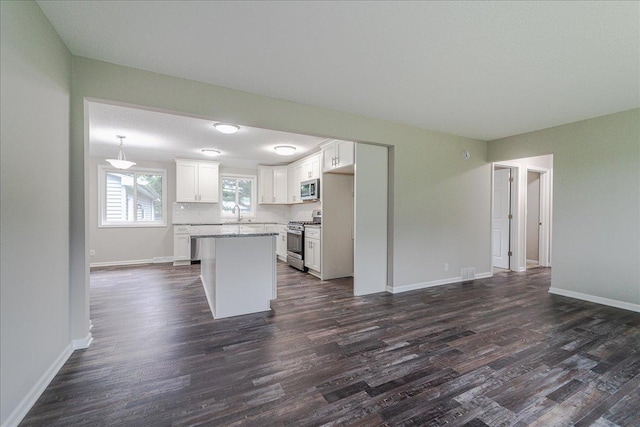 3667 205th St W, Farmington, MN 55024 - kitchen featuring appliances with stainless steel finishes, dark wood-style floors, white cabinetry, and a kitchen island