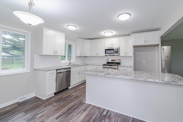 3667 205th St W, Farmington, MN 55024 - kitchen with appliances with stainless steel finishes, white cabinetry, dark wood-style floors, and a textured ceiling