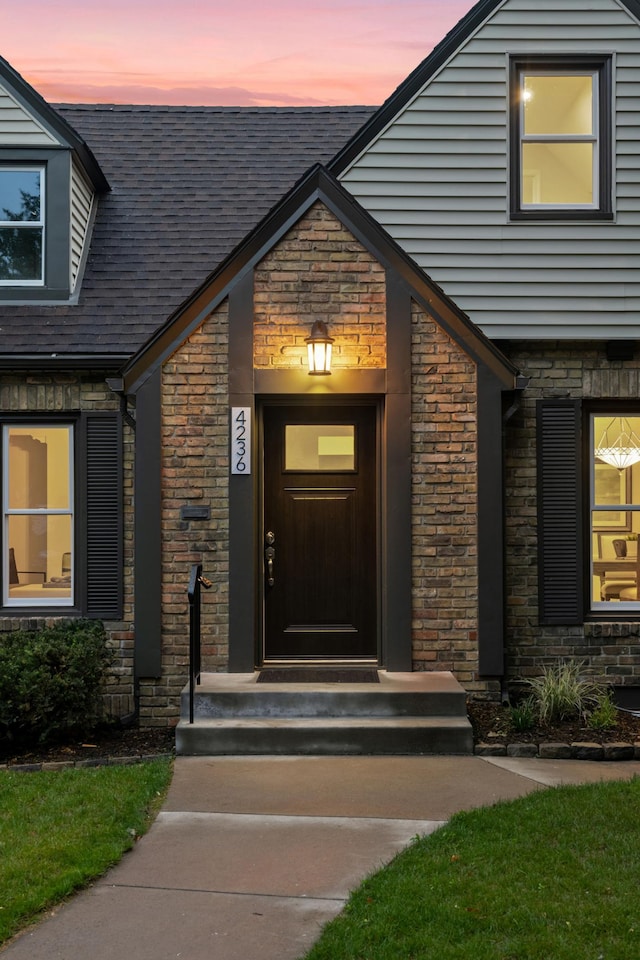 4236 22nd Ave S, Minneapolis, MN 55407 - exterior entry at dusk featuring stone siding and a shingled roof