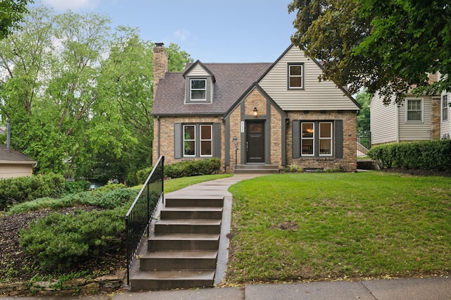 4236 22nd Ave S, Minneapolis, MN 55407 - tudor-style house featuring brick siding, a chimney, a front lawn, and roof with shingles