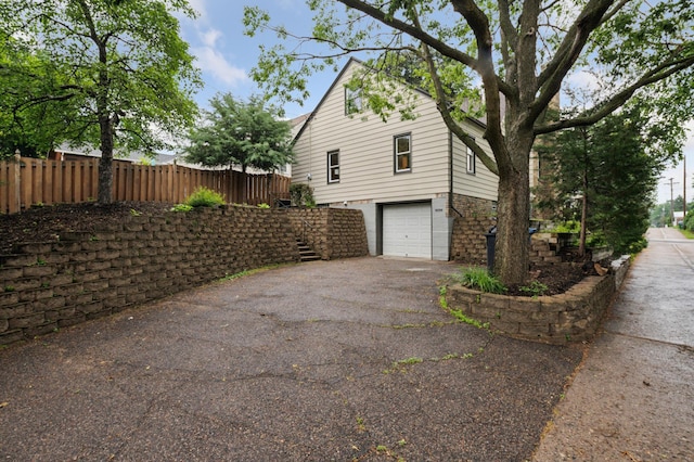 4236 22nd Ave S, Minneapolis, MN 55407 - view of side of home with asphalt driveway, stairs, and a garage