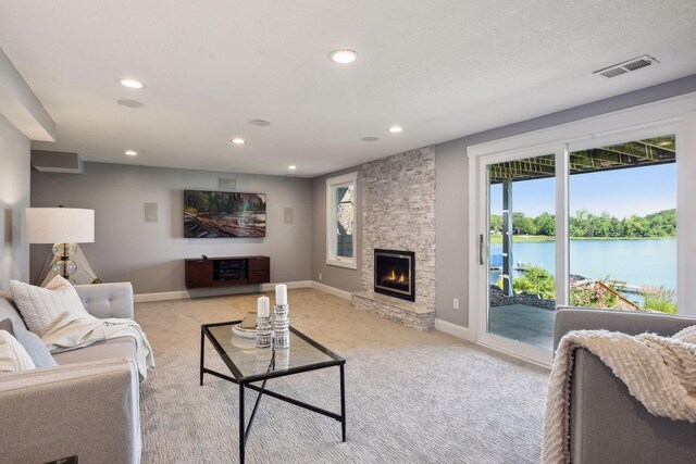 3590 Tuxedo Rd, Minnetrista, MN 55364 - living area featuring light carpet, recessed lighting, a water view, and a stone fireplace
