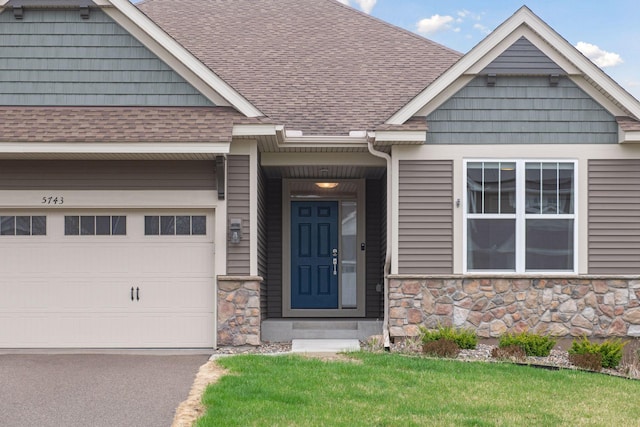 5743 Meridian Way NE, Prior Lake, MN 55372 - doorway to property with a shingled roof, stone siding, and driveway