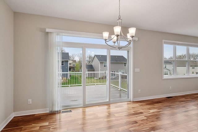 5743 Meridian Way NE, Prior Lake, MN 55372 - unfurnished dining area featuring a chandelier, wood finished floors, and plenty of natural light