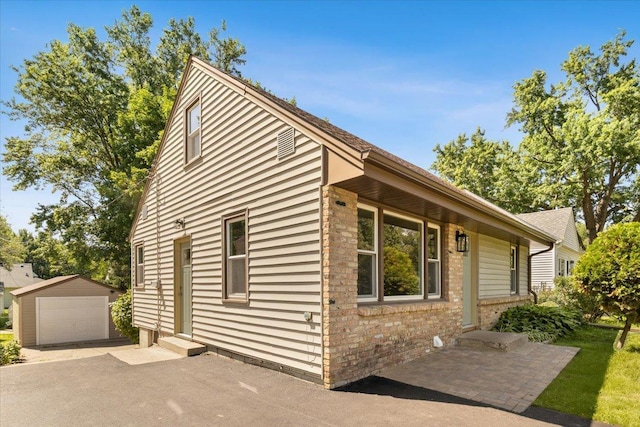 422 Jefferson Ave S, Edina, MN 55343 - view of side of home featuring an outdoor structure, brick siding, entry steps, and a detached garage