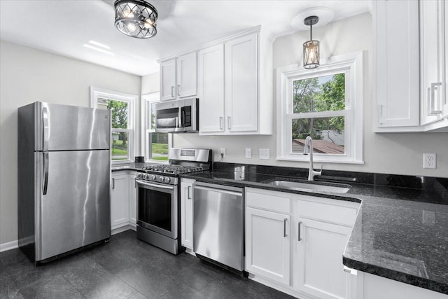 422 Jefferson Ave S, Edina, MN 55343 - kitchen with appliances with stainless steel finishes, white cabinets, dark stone counters, and hanging light fixtures
