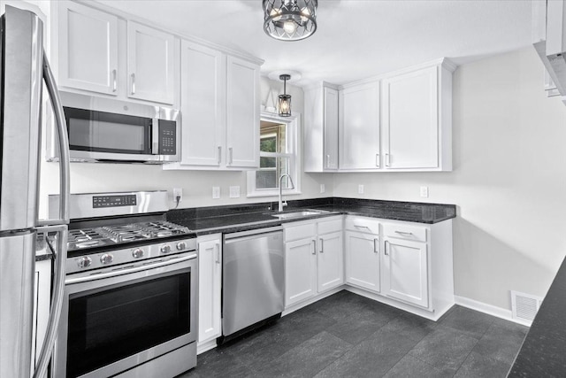 422 Jefferson Ave S, Edina, MN 55343 - kitchen with appliances with stainless steel finishes, white cabinets, dark stone countertops, and decorative light fixtures