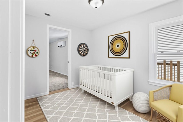 422 Jefferson Ave S, Edina, MN 55343 - bedroom featuring an AC wall unit, wood finished floors, and a nursery area