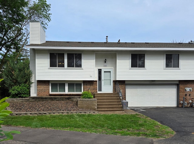 564 98th Ln NE, Blaine, MN 55434 - raised ranch featuring brick siding, an attached garage, asphalt driveway, and a chimney