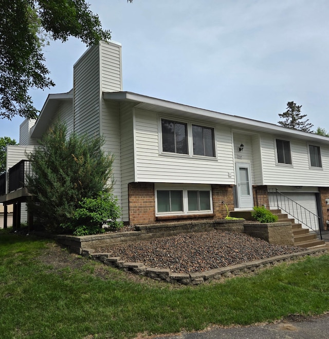 564 98th Ln NE, Blaine, MN 55434 - bi-level home featuring brick siding, a chimney, and an attached garage