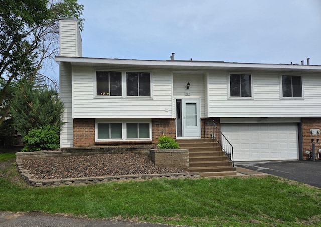 564 98th Ln NE, Blaine, MN 55434 - split foyer home featuring a garage, brick siding, asphalt driveway, and a chimney