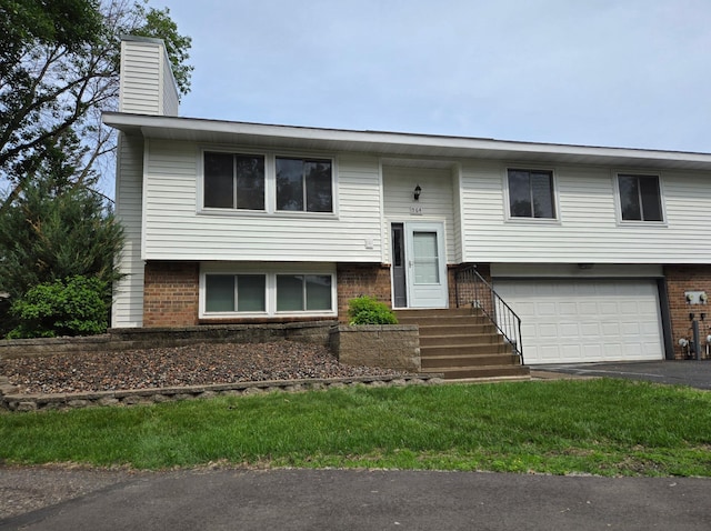 564 98th Ln NE, Blaine, MN 55434 - split foyer home featuring a garage, brick siding, asphalt driveway, and a chimney