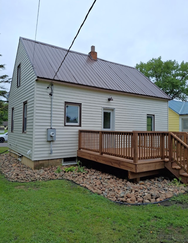 251 Colfax Ave NE, Hector, MN 55342 - back of property with a wooden deck, a chimney, a lawn, and a metal roof