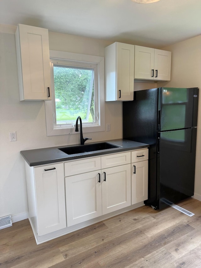 251 Colfax Ave NE, Hector, MN 55342 - kitchen with freestanding refrigerator, white cabinets, and dark countertops