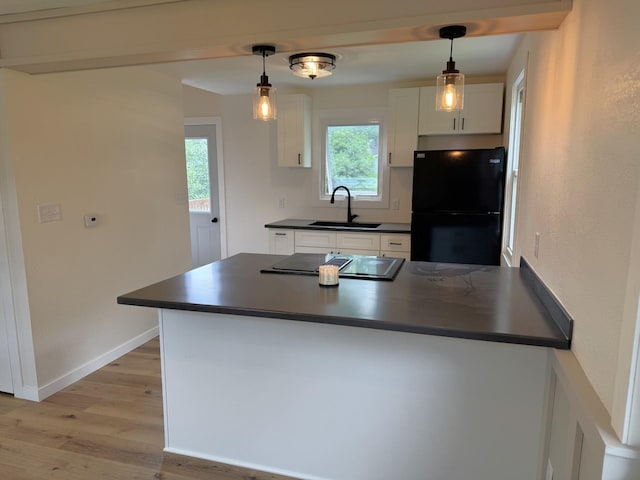 251 Colfax Ave NE, Hector, MN 55342 - kitchen with freestanding refrigerator, dark countertops, light wood-style floors, white cabinets, and stovetop with downdraft