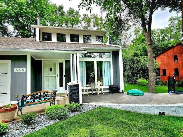 904 155th St, Burnsville, MN 55306 - view of front of house featuring a front lawn, covered porch, and a shingled roof