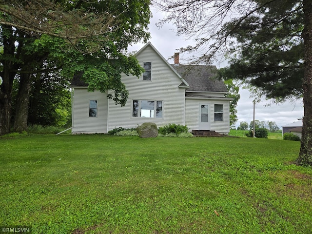 1264 389th Ave NE, Stanchfield Twp, MN 55080 - rear view of property with a chimney, a lawn, and roof with shingles