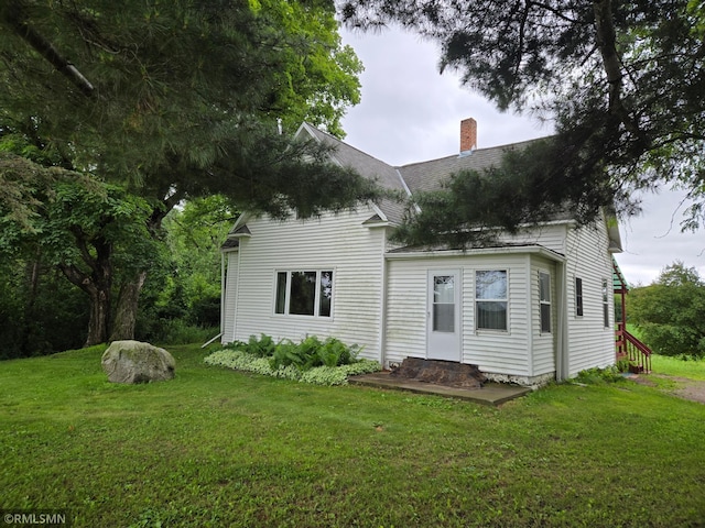 1264 389th Ave NE, Stanchfield Twp, MN 55080 - rear view of house with a chimney, roof with shingles, and a lawn