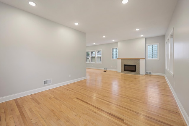 730 13th Ave S, Saint Cloud, MN 56301 - unfurnished living room featuring light wood-style floors, recessed lighting, plenty of natural light, and a fireplace