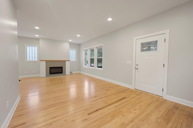 730 13th Ave S, Saint Cloud, MN 56301 - unfurnished living room featuring light wood finished floors, healthy amount of natural light, recessed lighting, and a brick fireplace