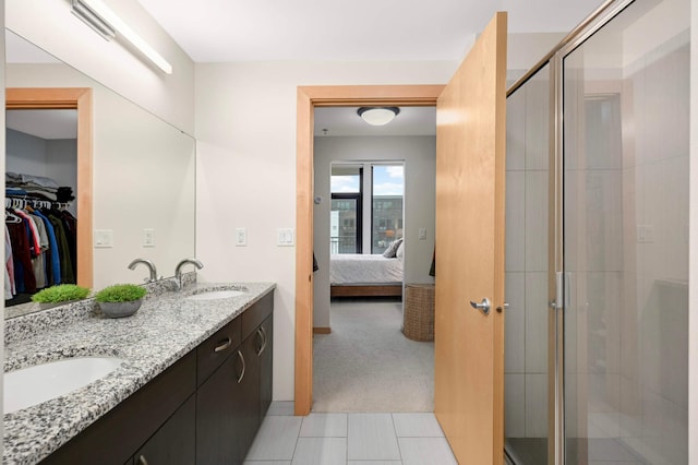 1120 2nd St Unit 1002, Minneapolis, MN 55415 - bathroom featuring ensuite bath, double vanity, a shower stall, a walk in closet, and tile patterned floors