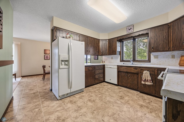611 4th St NE, Dilworth, MN 56529 - kitchen featuring white appliances, dark brown cabinets, a textured ceiling, light countertops, and tasteful backsplash