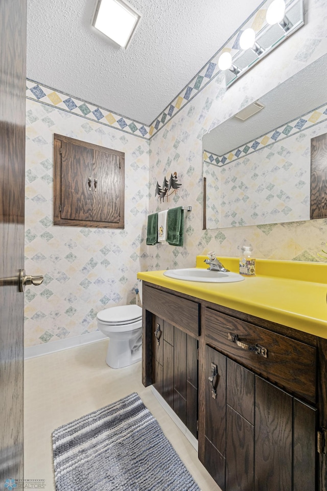 611 4th St NE, Dilworth, MN 56529 - bathroom featuring vanity, a textured ceiling, and wallpapered walls