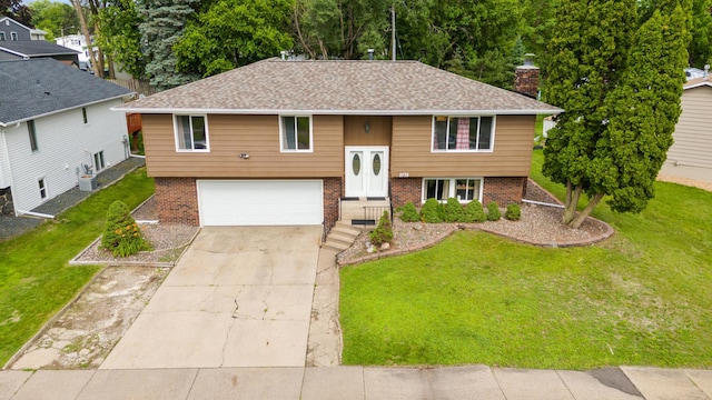 2735 Chisholm Ave N, Saint Paul, MN 55109 - bi-level home with brick siding, concrete driveway, a garage, and a front yard