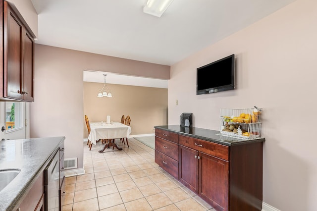 2735 Chisholm Ave N, Saint Paul, MN 55109 - kitchen featuring light tile patterned flooring, dark stone countertops, and hanging light fixtures