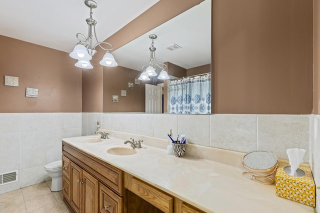 2735 Chisholm Ave N, Saint Paul, MN 55109 - full bathroom with double vanity, a chandelier, tile walls, and tile patterned floors