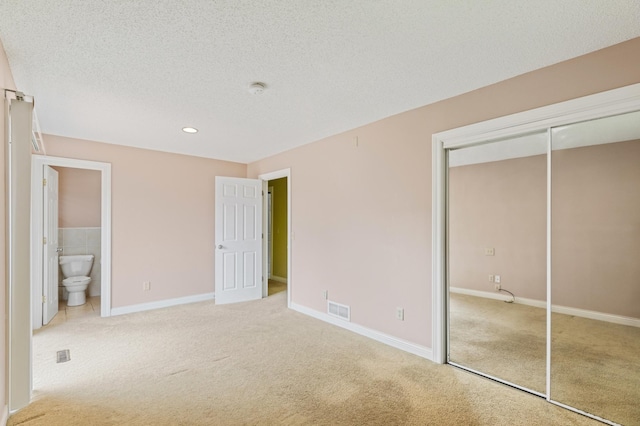 2735 Chisholm Ave N, Saint Paul, MN 55109 - unfurnished bedroom featuring light carpet, a closet, a textured ceiling, recessed lighting, and connected bathroom