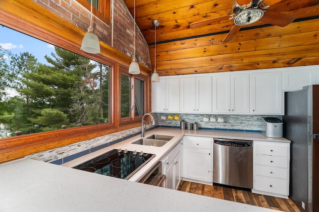 6618 Sumac Dr, Grand Lake Twp, MN 55803 - kitchen with appliances with stainless steel finishes, decorative backsplash, light countertops, white cabinetry, and wooden walls