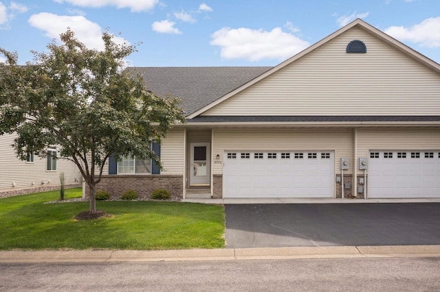 9775 Olive St NW, Coon Rapids, MN 55433 - view of front of property with driveway, a front yard, brick siding, an attached garage, and a shingled roof