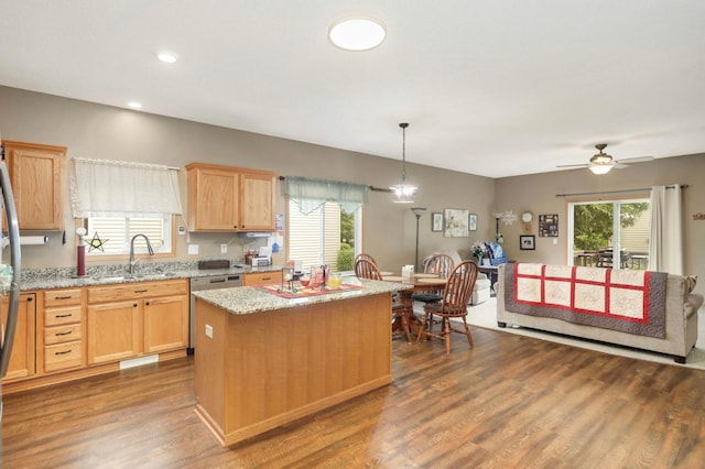 9775 Olive St NW, Coon Rapids, MN 55433 - kitchen featuring light brown cabinets, appliances with stainless steel finishes, wood finished floors, a center island, and light stone countertops