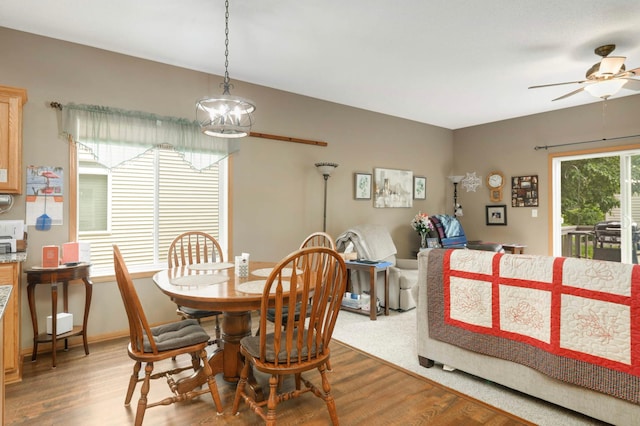 9775 Olive St NW, Coon Rapids, MN 55433 - dining area featuring light wood finished floors, a ceiling fan, and a chandelier