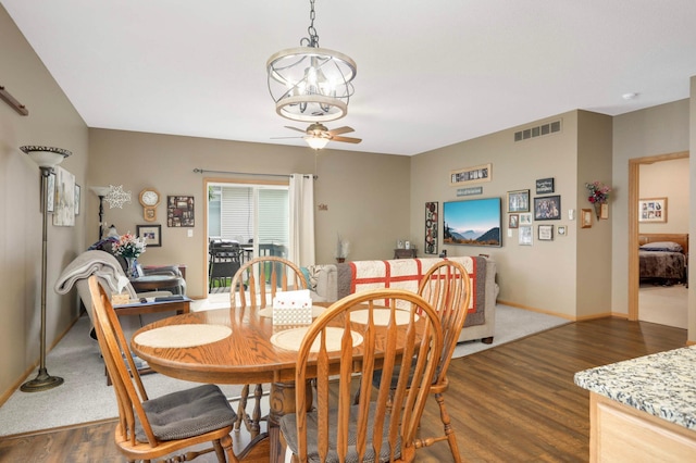9775 Olive St NW, Coon Rapids, MN 55433 - dining space featuring dark wood finished floors, ceiling fan, and a chandelier