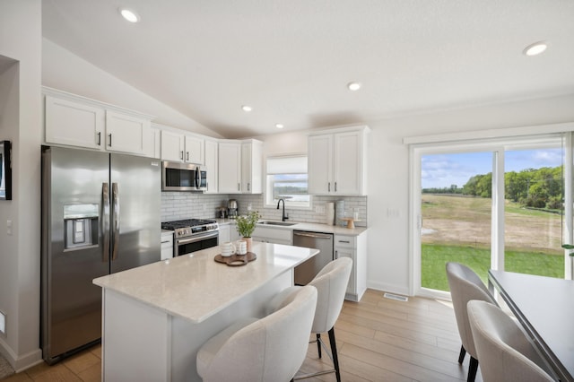 26645 8th St W, Zimmerman, MN 55398 - kitchen with stainless steel appliances, tasteful backsplash, lofted ceiling, white cabinetry, and a kitchen island