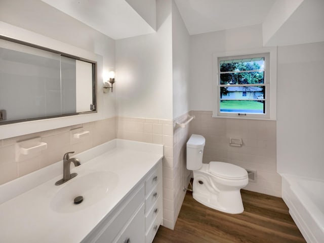 5808 Colfax Ave N, Brooklyn Center, MN 55430 - bathroom with tile walls, vanity, wood finished floors, a tub to relax in, and wainscoting