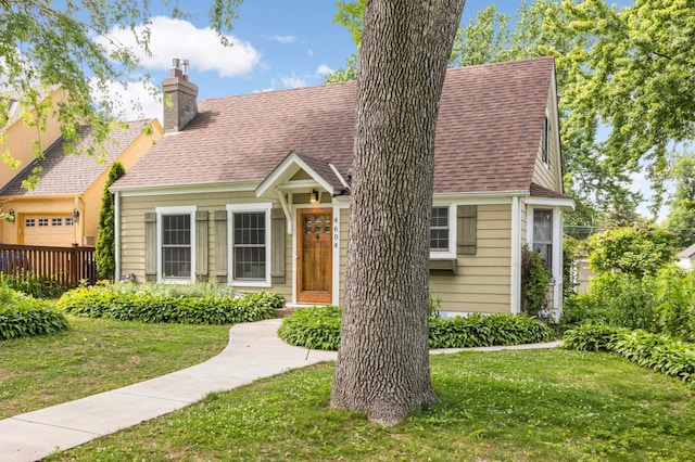 4604 39th St, Saint Louis Park, MN 55416 - new england style home featuring a chimney, a front yard, and roof with shingles