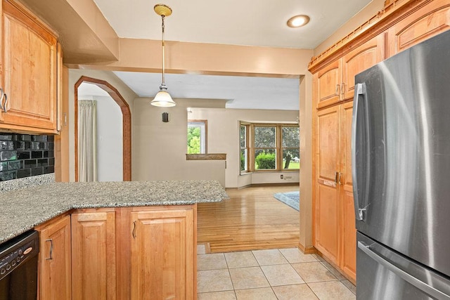 5120 Juniata St, Duluth, MN 55804 - kitchen featuring freestanding refrigerator, black dishwasher, light tile patterned flooring, decorative backsplash, and a peninsula