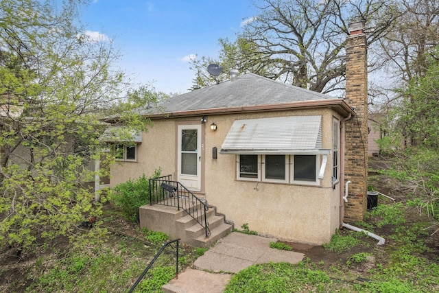 5123 Chicago Ave, Minneapolis, MN 55417 - view of front facade with a chimney, stucco siding, and a shingled roof