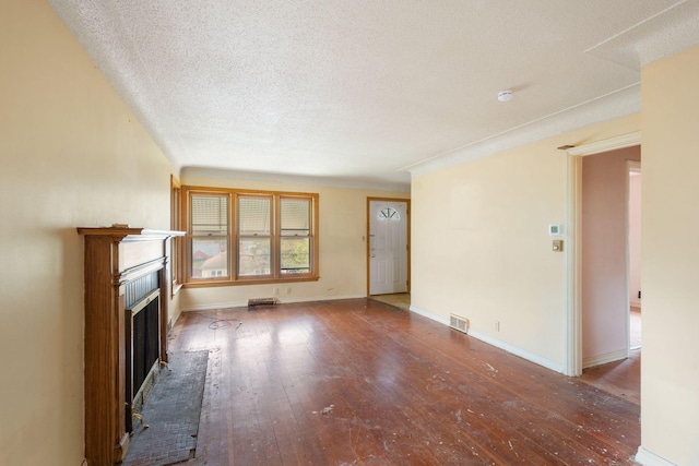 5123 Chicago Ave, Minneapolis, MN 55417 - unfurnished living room with hardwood / wood-style flooring, a fireplace with raised hearth, and a textured ceiling