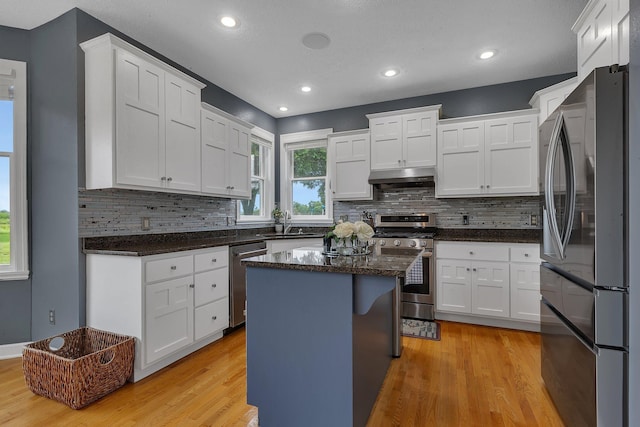 1302 Grizzly Ln, Sartell, MN 56377 - kitchen with appliances with stainless steel finishes, light wood finished floors, decorative backsplash, white cabinets, and recessed lighting