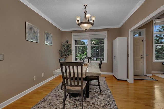 1302 Grizzly Ln, Sartell, MN 56377 - dining space featuring light wood-type flooring, a chandelier, a textured ceiling, and crown molding