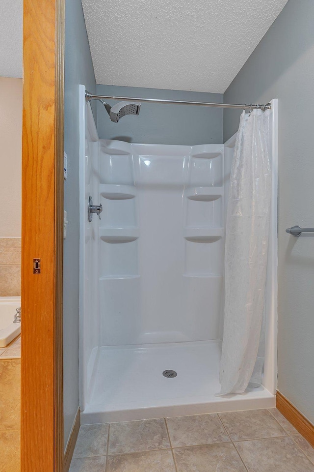 1302 Grizzly Ln, Sartell, MN 56377 - bathroom featuring a textured ceiling, a shower stall, and tile patterned flooring