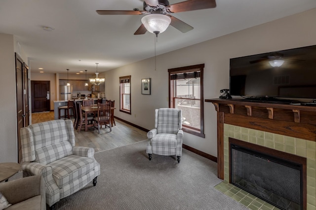 502 Cleveland Blvd Unit 3200, Walker, MN 56484 - living area featuring ceiling fan, a tiled fireplace, a chandelier, and light carpet